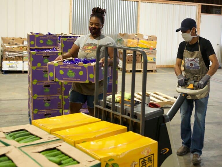 LaNeisha and Mauricio loading boxes of proudce onto pallet jack