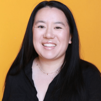 Phoebe smiling in front of orange background