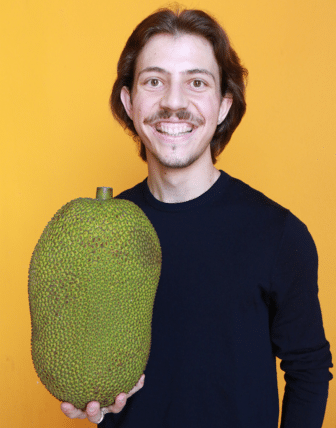 Michael smiling and holding jackfruit